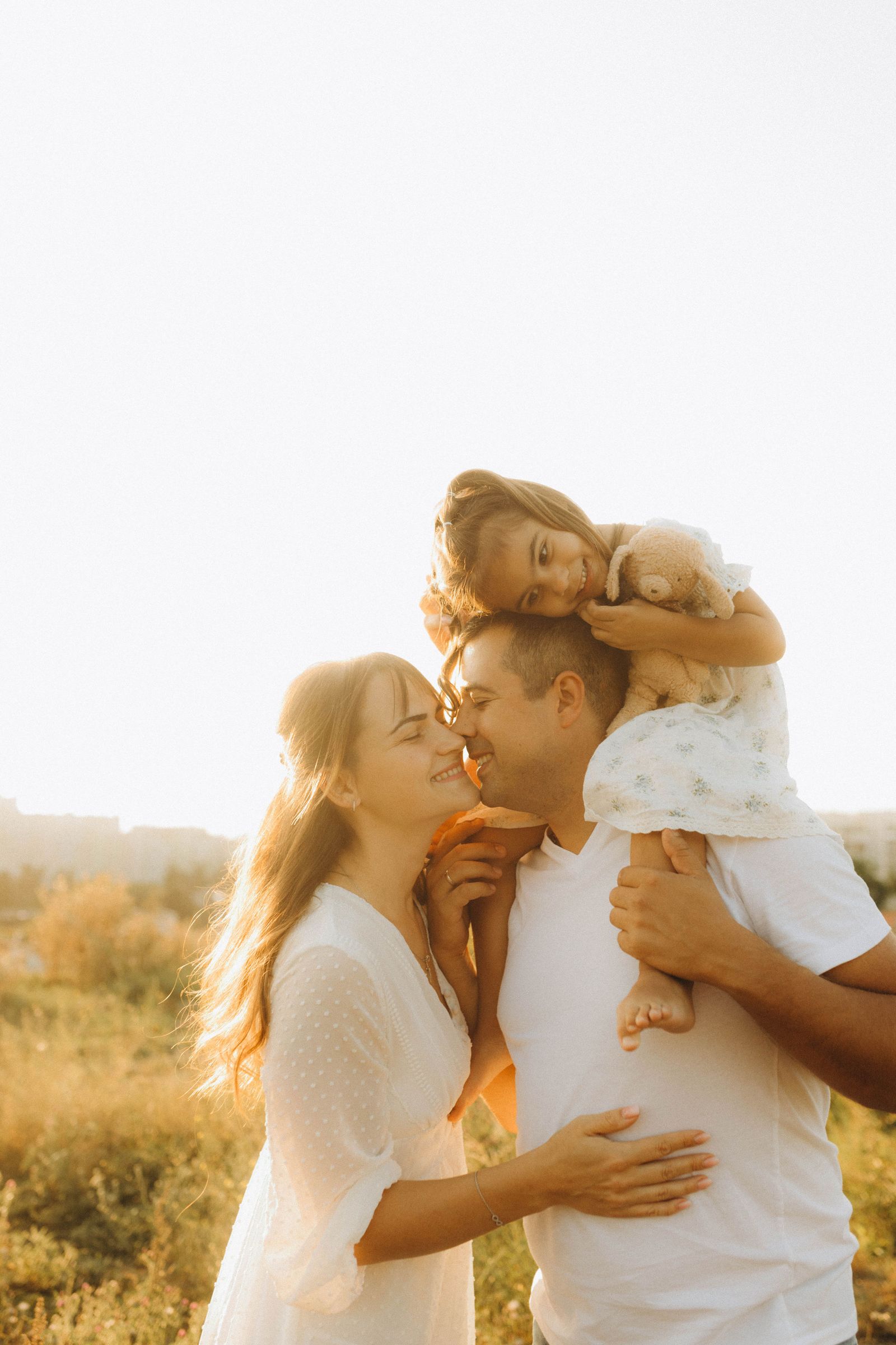 A happy family together outdoors in warm evening sunlight