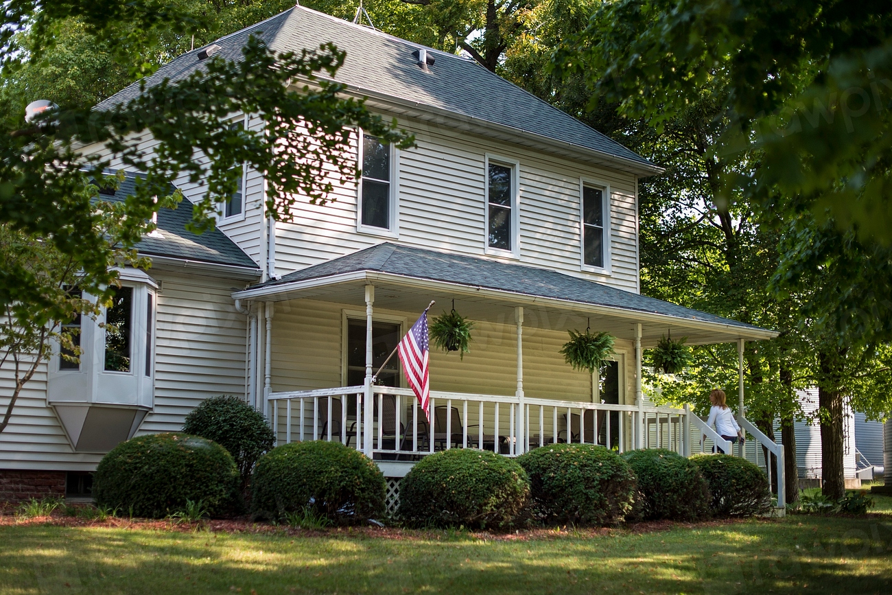 An American home flying the U.S. flag, framed by trees